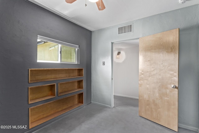 empty room featuring a ceiling fan, concrete floors, and baseboards
