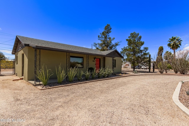 ranch-style home with stucco siding and roof with shingles