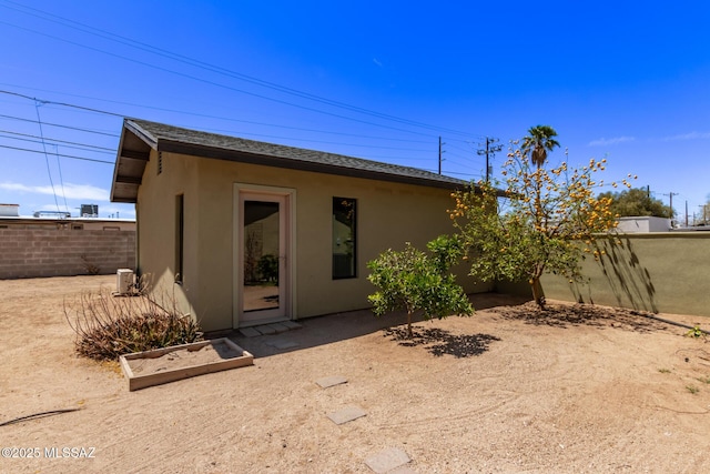 back of house with stucco siding and fence