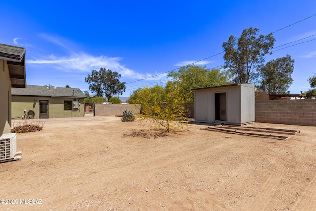 fenced backyard featuring a storage unit and an outdoor structure
