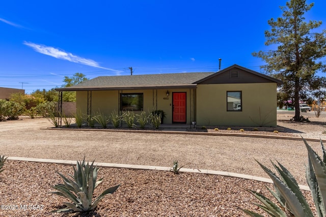 ranch-style house with stucco siding, covered porch, and roof with shingles