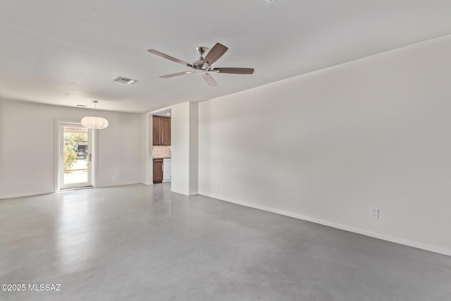 spare room with a ceiling fan, concrete floors, and baseboards