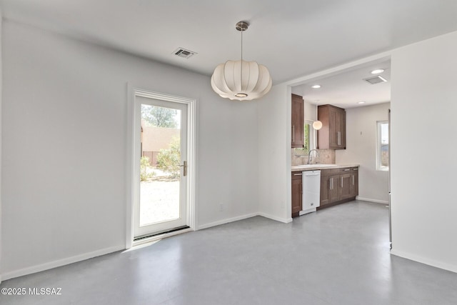 unfurnished dining area with a sink, concrete floors, baseboards, and recessed lighting