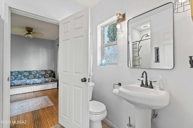 bathroom with wood-type flooring, ceiling fan, and toilet