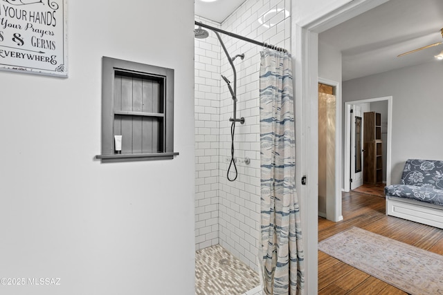 bathroom featuring hardwood / wood-style flooring, ceiling fan, and curtained shower