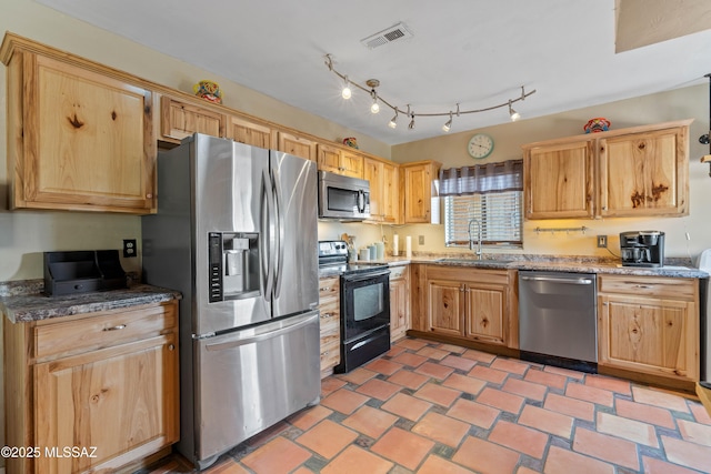 kitchen with stainless steel appliances, light stone countertops, and sink