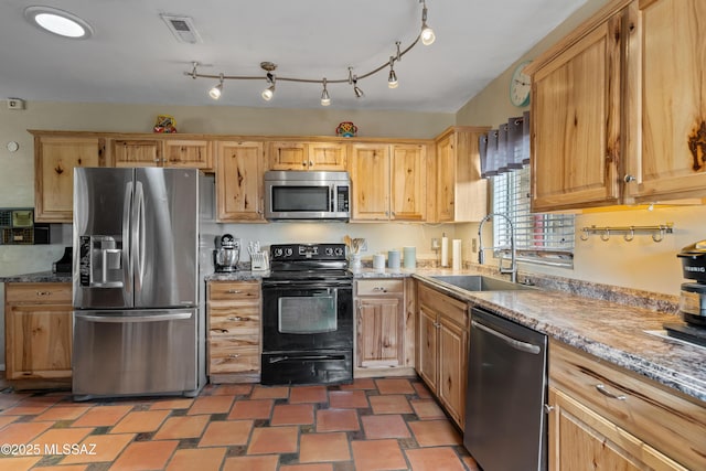 kitchen with light stone counters, appliances with stainless steel finishes, and sink