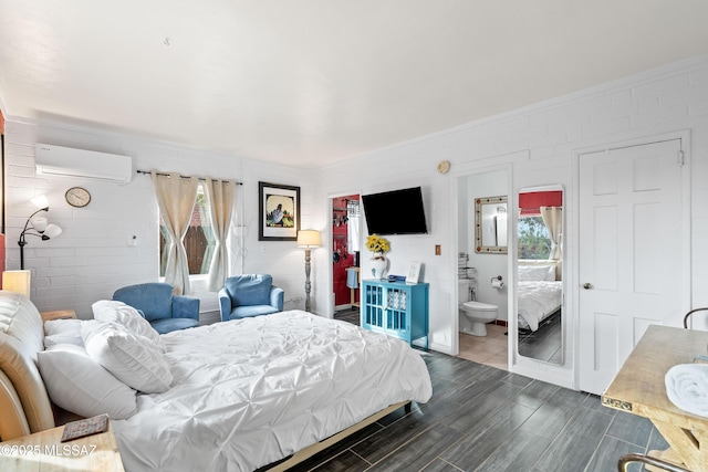 bedroom with hardwood / wood-style flooring, a wall mounted AC, and ensuite bathroom