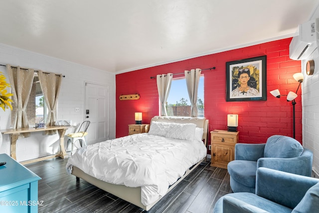 bedroom featuring multiple windows, brick wall, and a wall mounted air conditioner