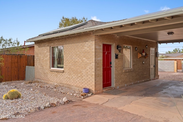 view of front of home with a patio area and solar panels