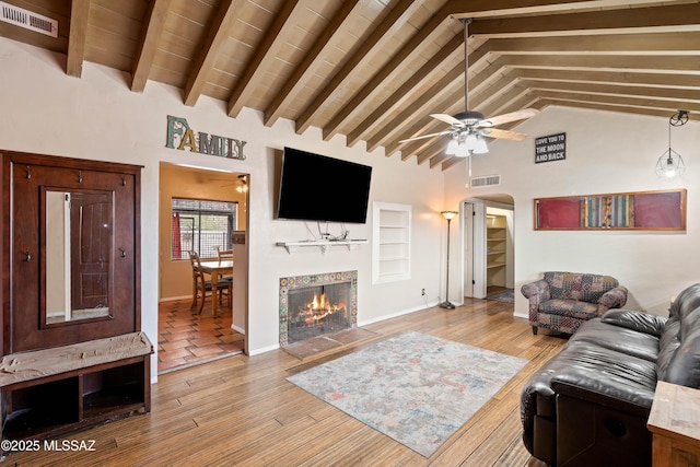 living room featuring high vaulted ceiling, built in features, ceiling fan, beam ceiling, and light hardwood / wood-style floors