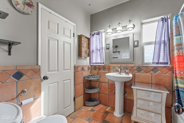 bathroom with tile patterned floors and tile walls