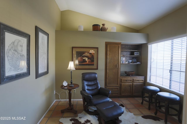 living area with lofted ceiling, baseboards, and light tile patterned floors