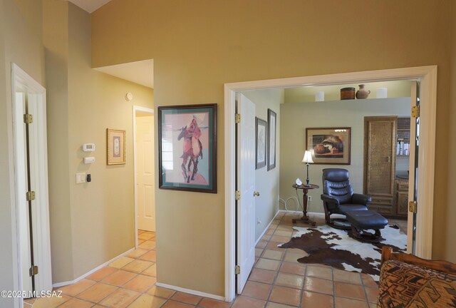 tiled living room with lofted ceiling, baseboards, visible vents, and a notable chandelier