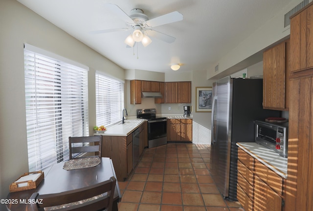 kitchen with tile patterned flooring, visible vents, light countertops, appliances with stainless steel finishes, and brown cabinets