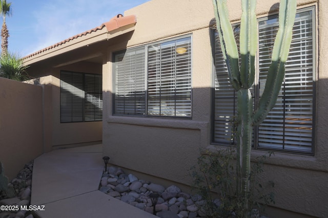 view of home's exterior featuring a tile roof and stucco siding