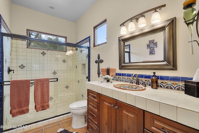 bathroom featuring tile patterned flooring, vanity, an enclosed shower, and toilet