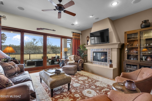 living room featuring hardwood / wood-style floors, a fireplace, and ceiling fan