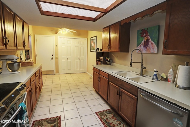 kitchen with sink, light tile patterned floors, ceiling fan, and appliances with stainless steel finishes