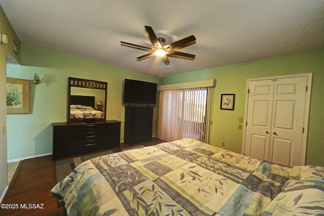 bedroom featuring ceiling fan, dark hardwood / wood-style floors, a closet, and a textured ceiling