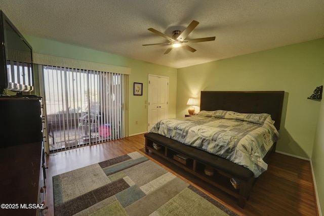 bedroom featuring ceiling fan, dark wood-type flooring, and a textured ceiling