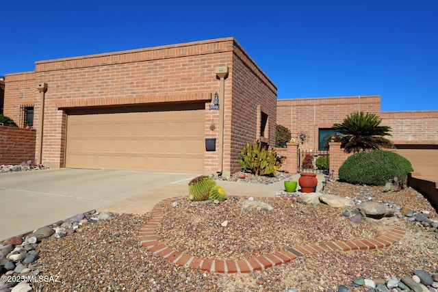 view of front of property featuring brick siding, a garage, and concrete driveway