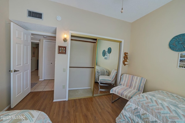 bedroom featuring hardwood / wood-style floors and a closet