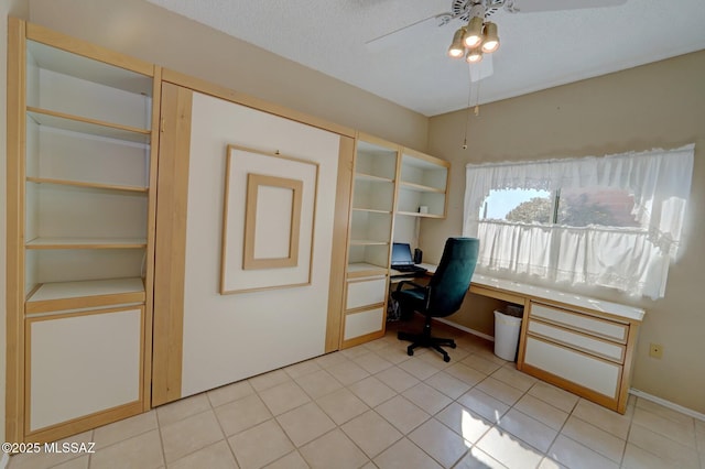 tiled office space featuring a textured ceiling and ceiling fan