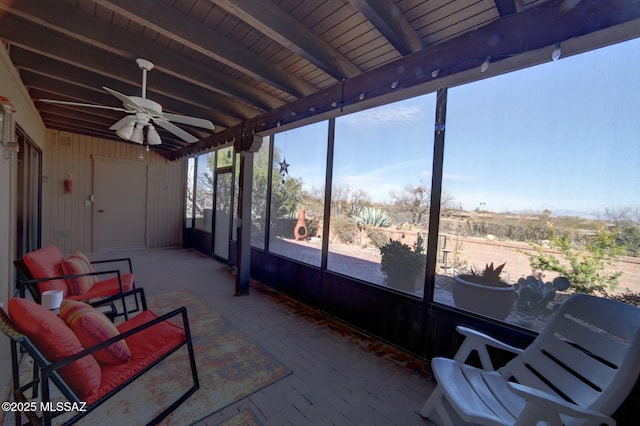 sunroom / solarium featuring ceiling fan and beam ceiling