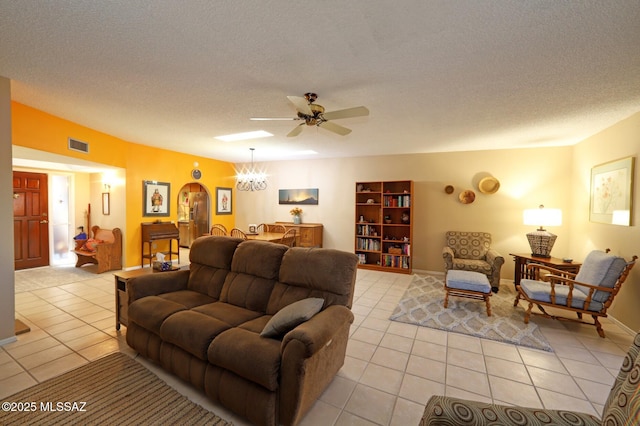 living room with ceiling fan with notable chandelier, a textured ceiling, and light tile patterned floors