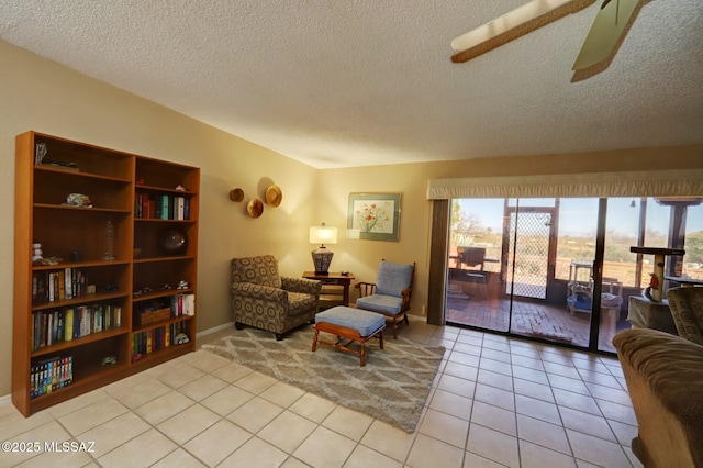 sitting room featuring light tile patterned floors, a textured ceiling, and ceiling fan