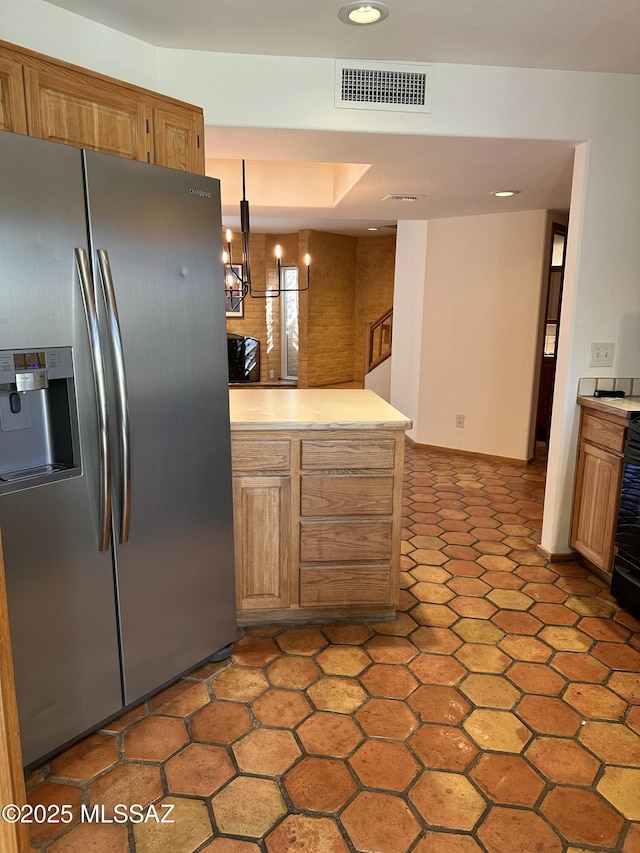 kitchen featuring stainless steel refrigerator with ice dispenser, an inviting chandelier, and decorative light fixtures