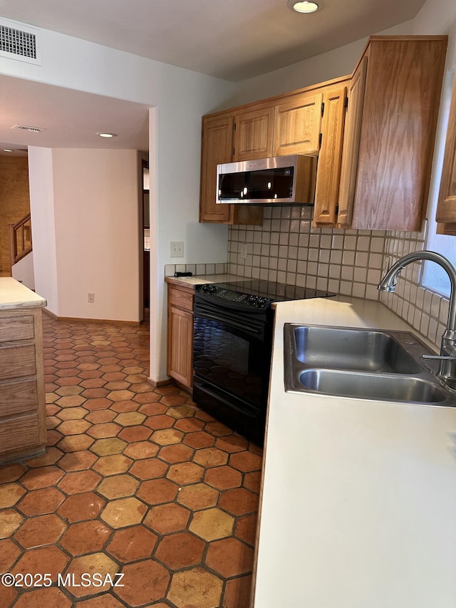 kitchen with sink, decorative backsplash, black range with electric cooktop, and light tile patterned floors