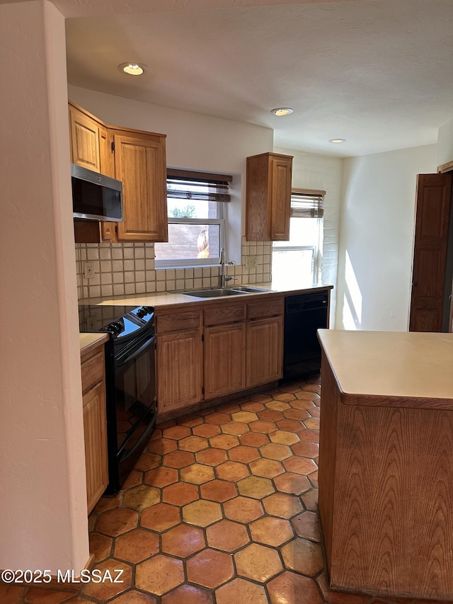 kitchen with tasteful backsplash, sink, light tile patterned floors, and black appliances