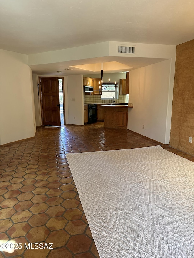 unfurnished living room featuring dark tile patterned floors, sink, and a wealth of natural light