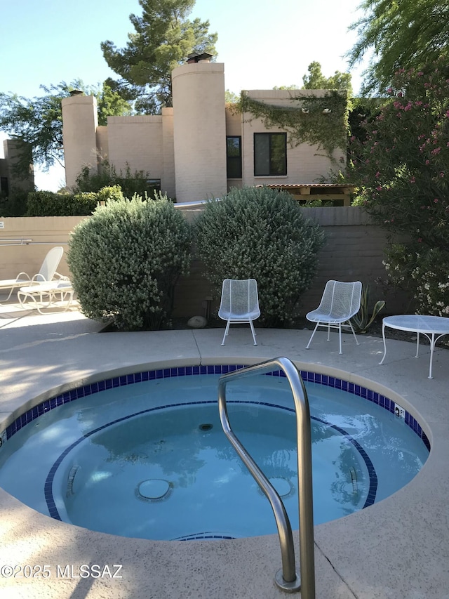 view of pool with a hot tub and a patio area