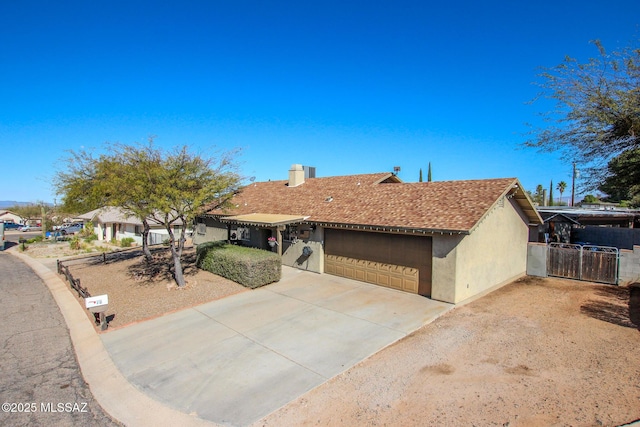 ranch-style home featuring stucco siding, concrete driveway, an attached garage, a gate, and fence