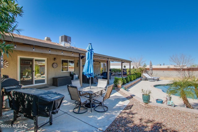 view of patio featuring a fenced in pool, outdoor dining area, and central AC unit