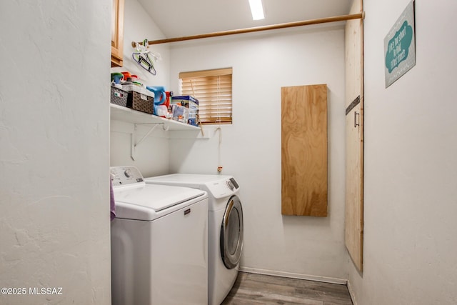 laundry area with washing machine and dryer, laundry area, and wood finished floors