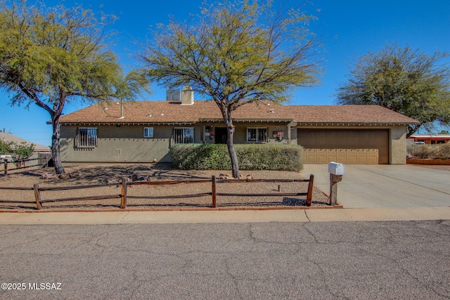 ranch-style house with a garage, concrete driveway, a fenced front yard, a chimney, and stucco siding