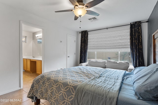 tiled bedroom with connected bathroom, sink, and ceiling fan