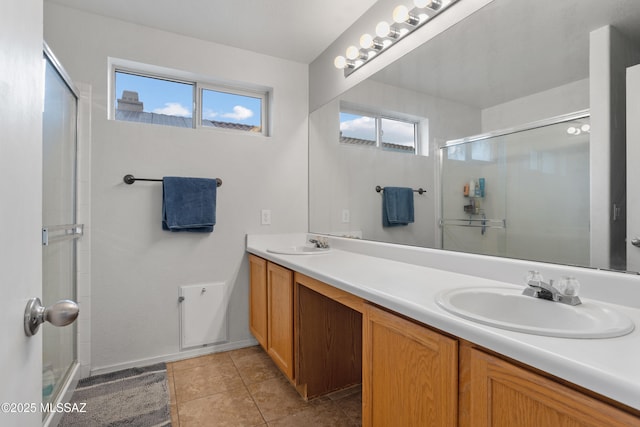 bathroom featuring tile patterned floors, a shower with door, and vanity