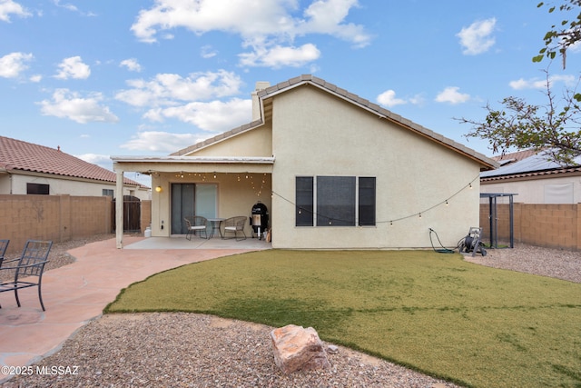 rear view of house with a yard and a patio area