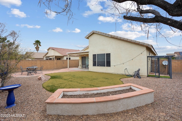 rear view of house featuring a trampoline, a yard, and a patio area