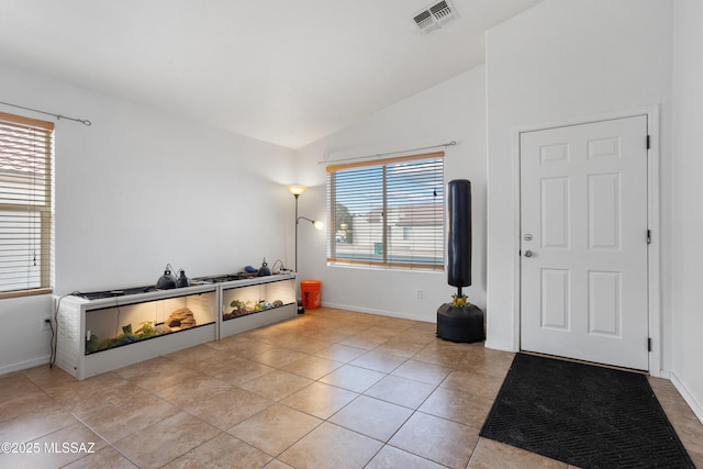 foyer entrance featuring vaulted ceiling and light tile patterned flooring