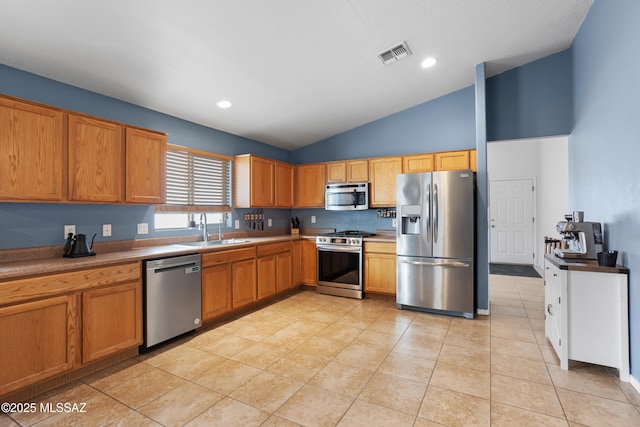 kitchen with stainless steel appliances, lofted ceiling, sink, and light tile patterned floors