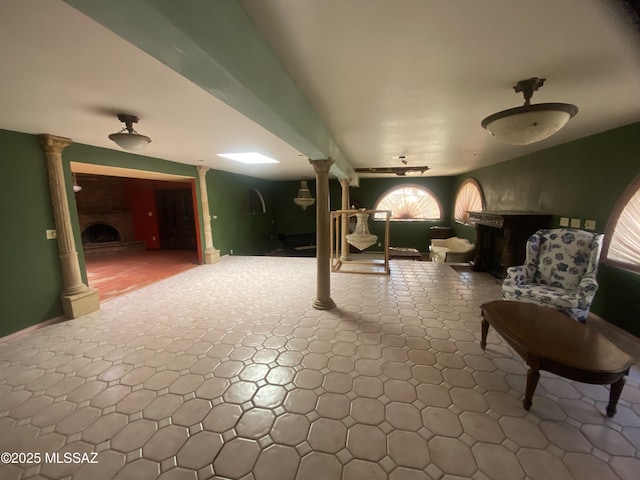 living area featuring decorative columns and a fireplace