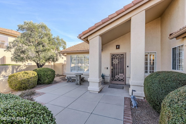 36425 S Golf Course Dr, Tucson, AZ 85739 - doorway to property featuring a tile roof, a patio area, fence, and stucco siding