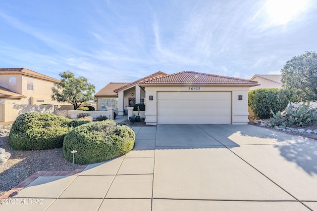 36425 S Golf Course Dr, Tucson, AZ 85739 - mediterranean / spanish house featuring stucco siding, a tile roof, fence, concrete driveway, and an attached garage