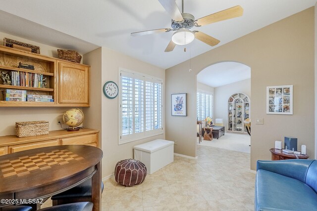 36425 S Golf Course Dr, Tucson, AZ 85739 - interior space featuring baseboards, ceiling fan, vaulted ceiling, light tile patterned floors, and arched walkways
